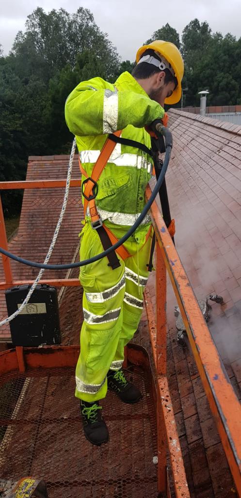 Man steam cleaning roof